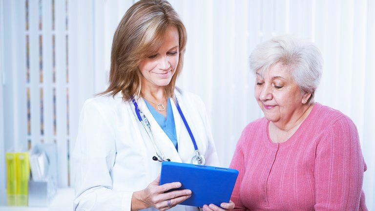 Lekar i pacijent gledaju u tablet